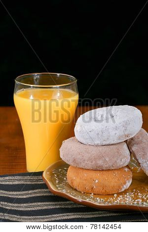 Assorted donuts on a plate with orange juice