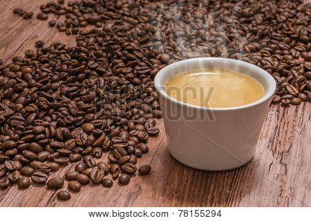 Cup Of Coffee And Spilled Coffee Beans