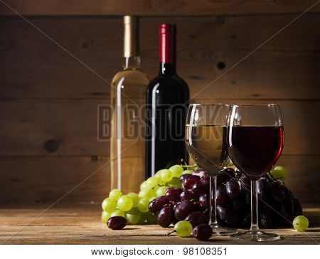 Red and white wine on wooden background