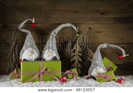 Funny christmas decoration with santa and apple green and red presents on wooden snowy background.