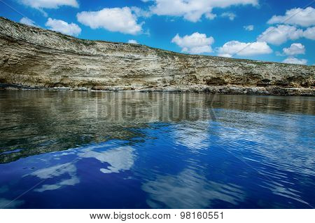 Seascape, Rocks Against A Blue Sky With Clouds