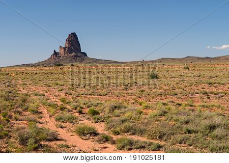 Agathla Peak or El Capitan along U.S. Route 163 between Monument Valley and Kayenta raises 1500 feet above the surrounding prairie.