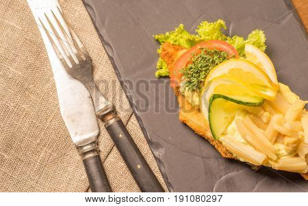 Danish specialties and national dishes high-quality open sandwich served on a plate ready for eating. fish fillet and garnished with remoulade and lemon