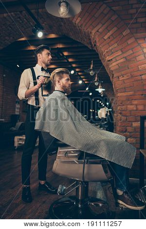 Full Length Of Handsome Classy Dressed Barber Shop Stylist, Who Is Presenting The Result Of His Styl