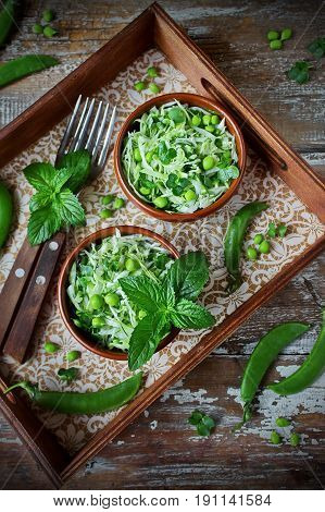fresh vegetable salad with white cabbage, green peas and mint - healthy vegetarian food