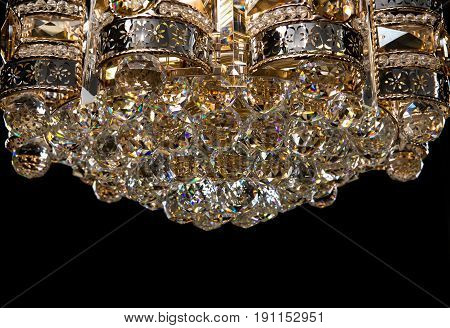 Large crystal chandelier close-up in baroque style isolated on black background. Luxury royal expensive chandelier for living room, Hall of celebration.