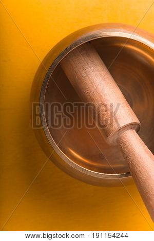 Tibetan singing bowl  on the yellow background top view vertical