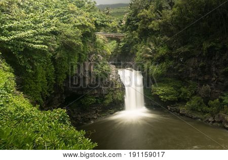 Road to Hana continues over bridge over waterfall into Seven Sacred Pools at state park