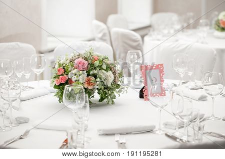 table setting, festive round tables ready for guests. Beautifully organized event. floral arrangement in the center. fresh flowers cut-off