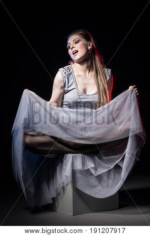 Actress In A Grey Dress On A Dark Stage