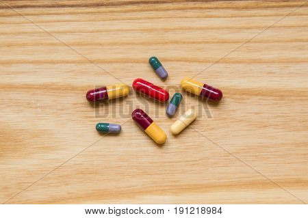 Lot Of Colorful Pills On A Wooden Table