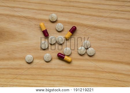 Lot Of Colorful Pills On A Wooden Table