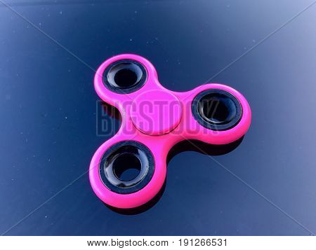 purple fidget spinner stress relieving toy on dark background