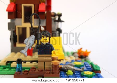 Colorado, USA - June 14, 2017: Studio shot of cute LEGO minifigure boy fishing with cabin in the background.
