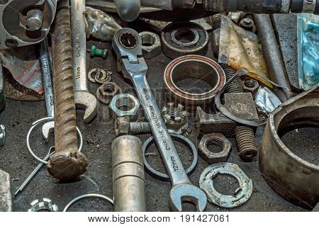 Old nuts, bolts, screws and instruments at car repair shop