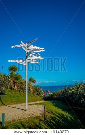 SOUTH ISLAND, NEW ZEALAND- MAY 23, 2017: Unidentified people looking at signpost at Cape Foulwind on the west coast of the South Island of New Zealand.