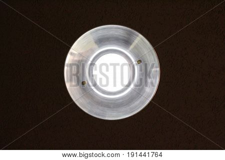 glowing round light bulb against a dark background, bottom view