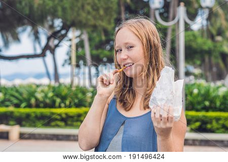 Women Eat Fried Sweet Potatoes In The Park. Junk Food Concept
