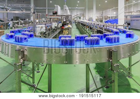 Packed cans on the conveyor belt in berverage factory