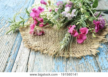 Field flowers over old wooden table background.