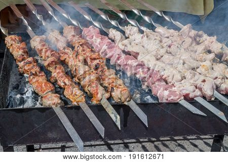 Marinated shashlik preparing on a barbecue grill over charcoal. Shashlik or Shish kebab popular in Eastern Europe. Shashlyk skewered meat was originally made of lamb. Roast Beef Kebabs On BBQ Grill.