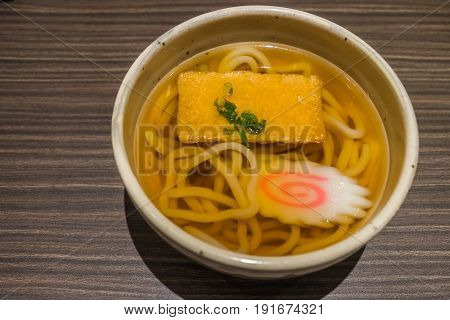 Kitsune Udon Japanese Noodles In White Bowl On Wooden Table