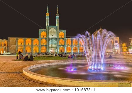 YAZD, IRAN - MAY 5, 2015: People socializing by the fountain and Amir Chakhmaq Complex in old city. Long exposition.