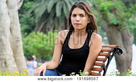 Worrisome Hispanic Female Sitting in a Public Park