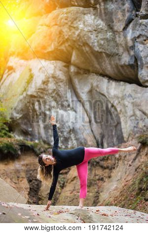 Sporty Fit Girl Is Practicing Yoga And Doing Asana Ardha Chandrasana On The Boulder In The Nature. H