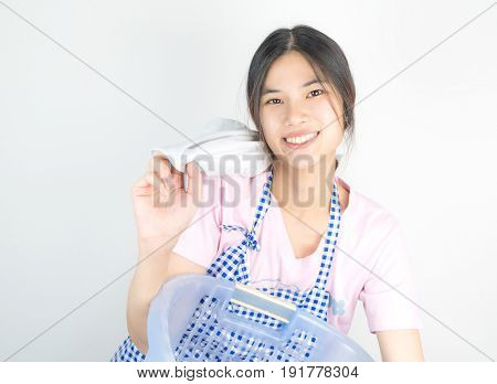 Happy Asian Housewife is enjoying house work by cleaning up clothes and laundry.