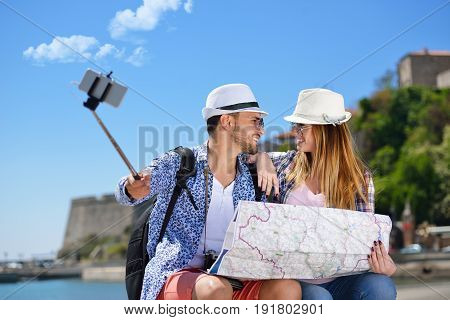 Couple of tourists photographing a selfie in a city street