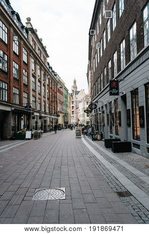 Copenhagen Denmark - August 11 2016. Commercial street with sidewalk cafe in historical city centre of Copenhagen a cloudy day of summer