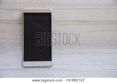 smarth phone on wooden table with blank screen