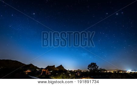 Blue Night Sky with Neighborhood Silhouette of houses stars