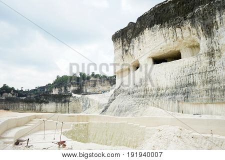 The exploitation of limestone hills forming a unique architectural in Jeddih or Jaddih Hill Madura Island, Indonesia