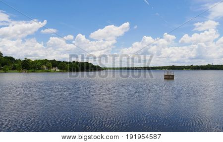 Cottony clouds above Guthrie Lake 
Fluffy cottony clouds rise above Guthrie Lake in Guthrie, Oklahoma on a sunny day.