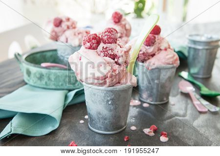 Homemade raspberry ice cream in small tin cups
