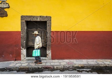 San Miguel de Allende Mexico - May 29 2014: Man passing in front of a door in the historic center of the city of San Miguel de Allende Mexico.