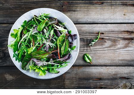 Mix Of Fresh Leaves With Arugula, Lettuce, Beets. Ingredients For Salad On A Wooden Background.