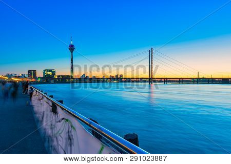Duesseldorf, Germany - March 22, 2019: Inidentified Pedestrans Stroll Along The Rhine Promenade In T