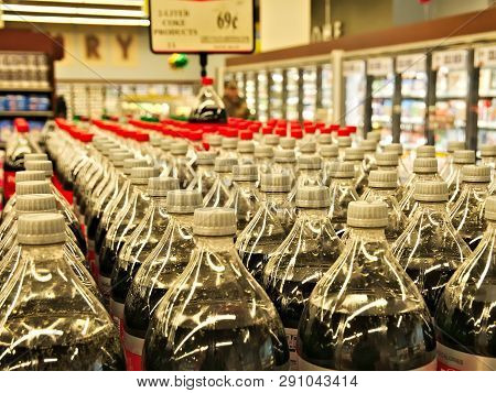 Rows Of Plastic Bottles Of Soda Carbonated Beverages Stacked On Shelves In A Local Supermarket.
