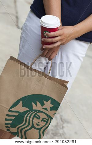 Paphos, Cyprus - November, 23 2013 Woman Standing On The Street With Starbucks Takeaway Paper Bag An