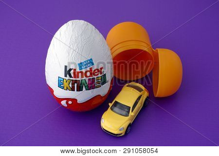 Paphos, Cyprus - November 27, 2015 Kinder Surprise Egg, Plastic Capsule And Car Toy On Purple Backgr