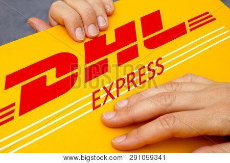 Tambov, Russian Federation - June 01, 2015 Dhl Express Package In Woman Hands. Studio Shot.
