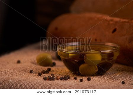Fresh Bread Baguette With Olive Oil, Olives. Cheese And Rosemary On Wooden Background. Teasty Breakf