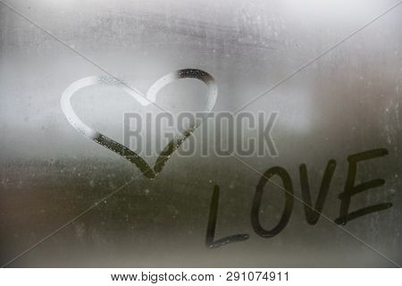 Beautiful Heart Symbol And Love Word On The Glass Window With Water Drobs.