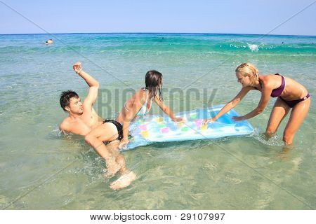 Gruppo di tre amici - uomo e donna - sulla spiaggia avendo un sacco di divertimento in vacanza in Grecia