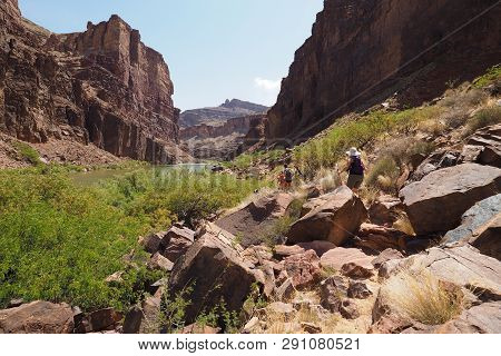 Hikers On A Trail Bordering The Colorado River Above Hance Rapids In Grand Canyon National Park, Ari