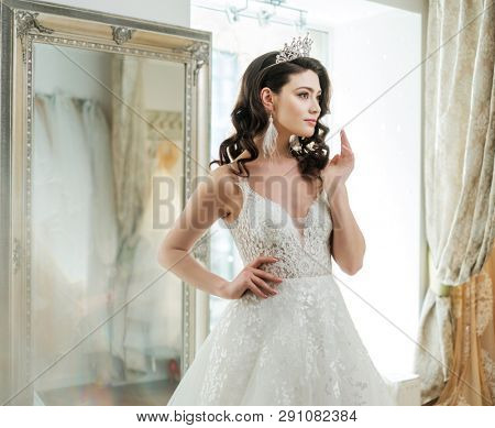 Beautifu bride choosing wedding dress in a wedding salon