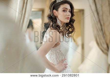 Beautifu bride choosing wedding dress in a wedding salon